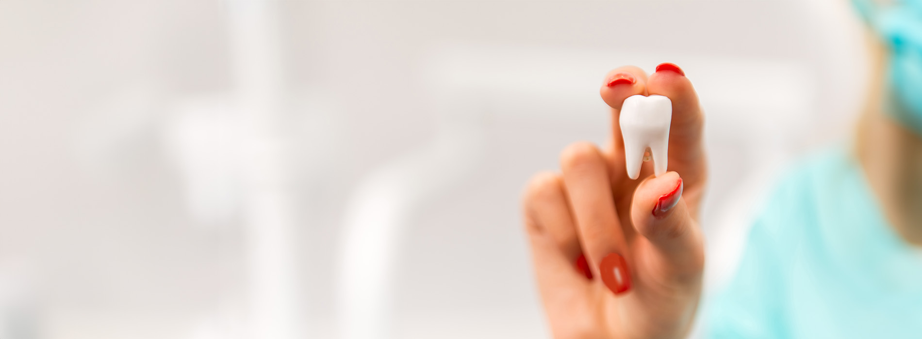 The image features a close-up of a person s hand holding a small white object, which appears to be a toothbrush or dental tool.