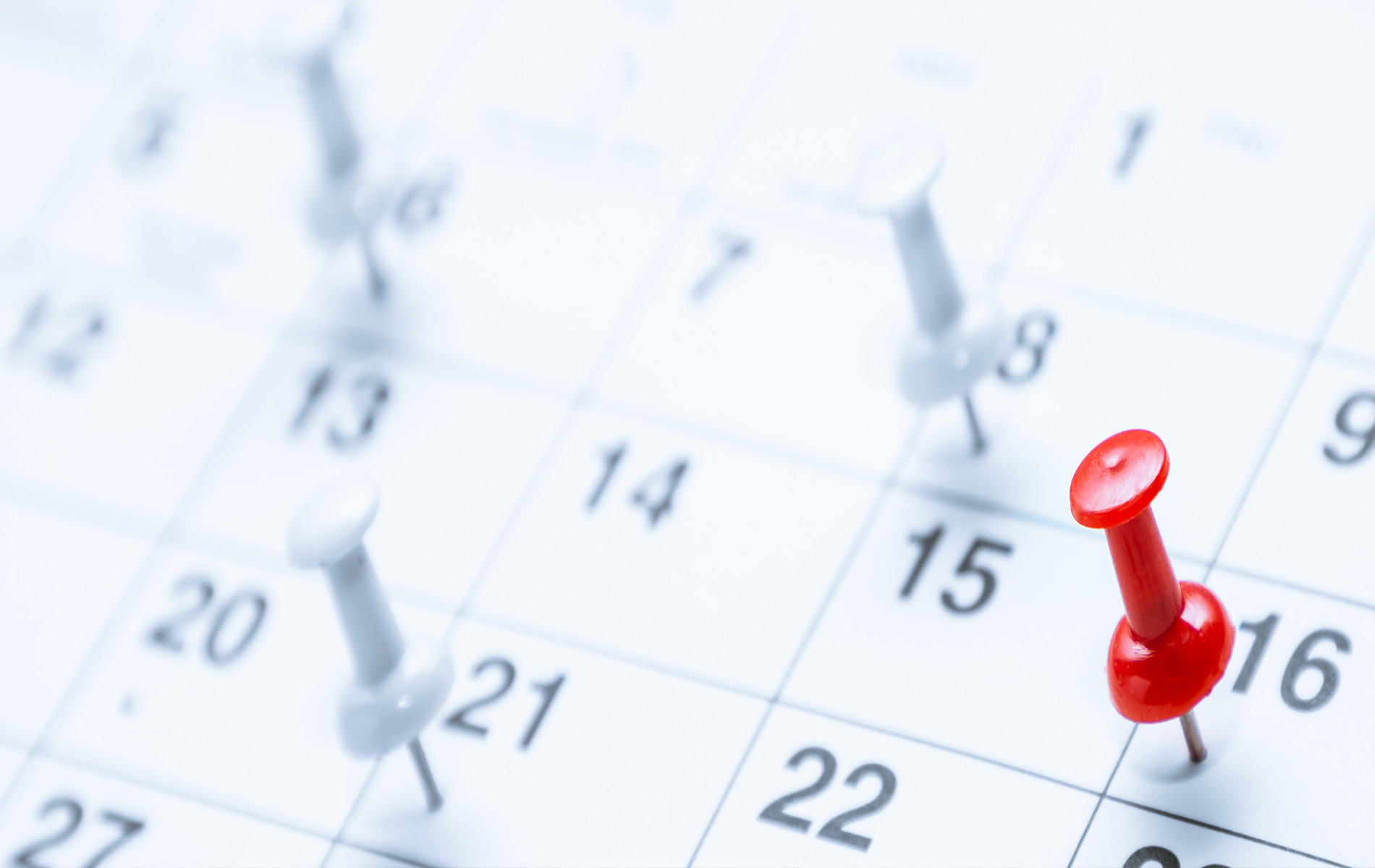 The image shows a close-up of a calendar with a red pin on the 21st, indicating an event or reminder scheduled for that day.