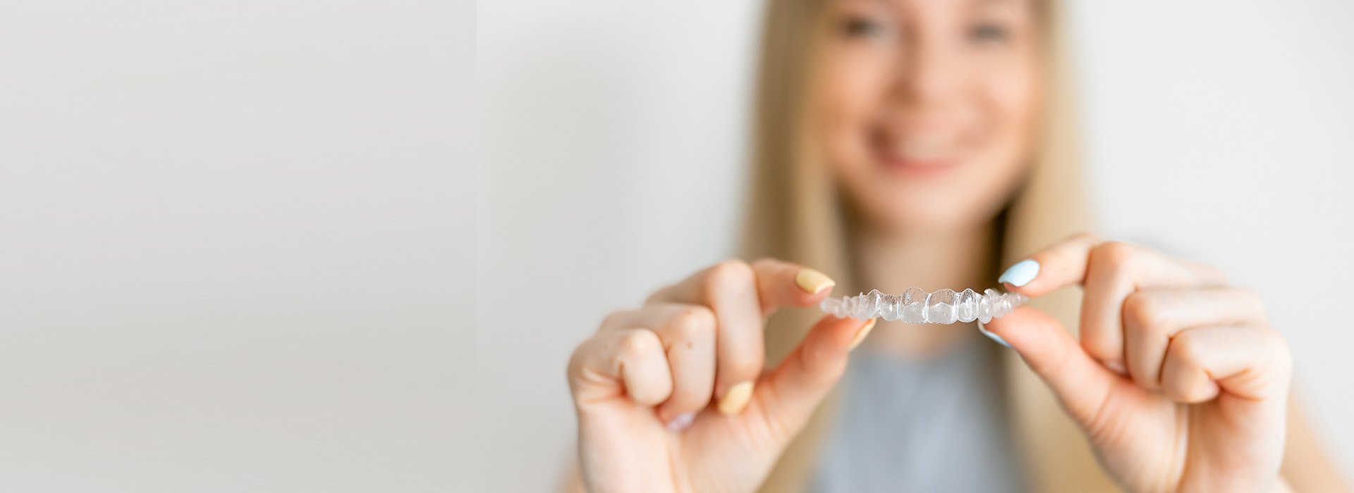 A person holding a ring in their hand, against a blurred background.